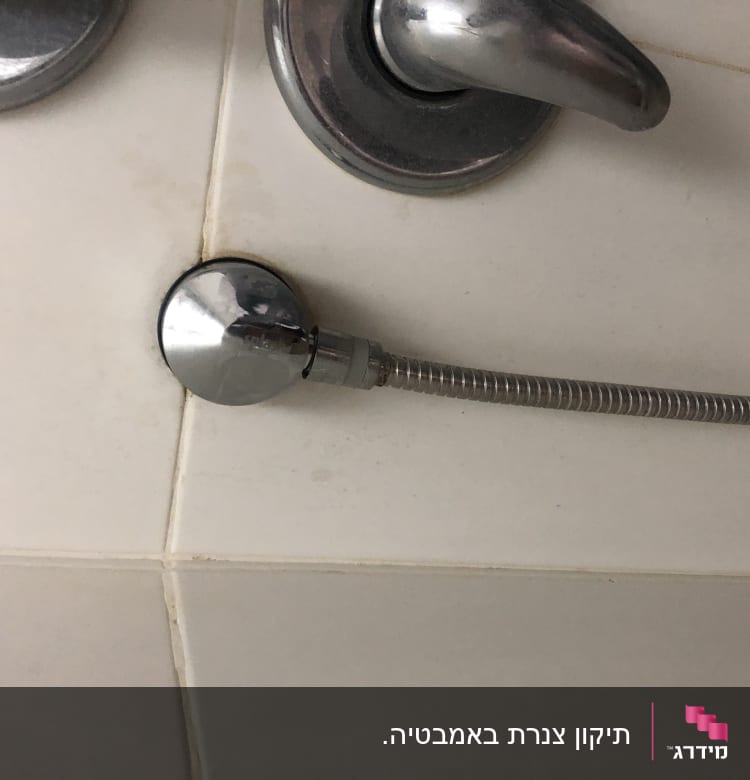 ברז מתכת עם צינור גמיש מחובר לקיר